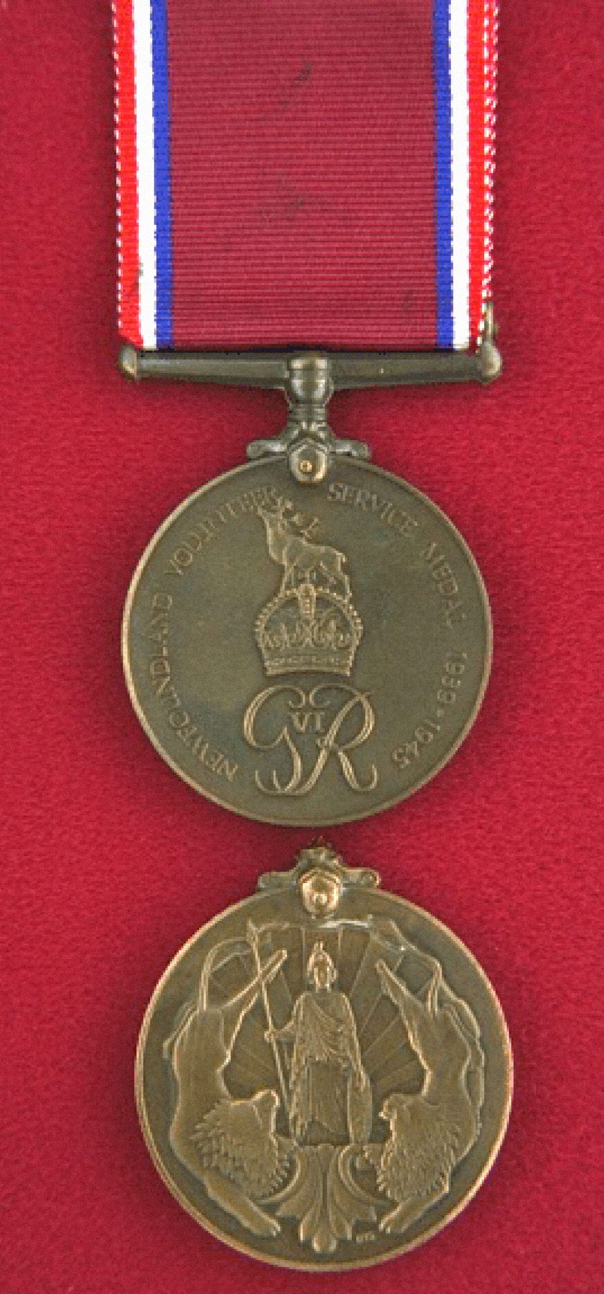 A circular bronze-coloured medal is suspended from a maroon ribbon with red-white-and-blue stripes on its outside edges. The front of the medal features a Newfoundland caribou over a royal crown, the name of the medal and the years 1939–1945. The back shows Britannia holding a spear with sun rays at her back. She is flanked by two lions.